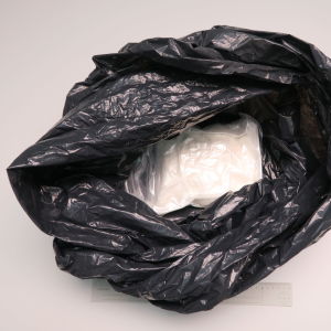 Polisen har beslagtagit kring 2 kilo amfetamin. En svart påse, med en plastpåse med ett vitt pulver i.