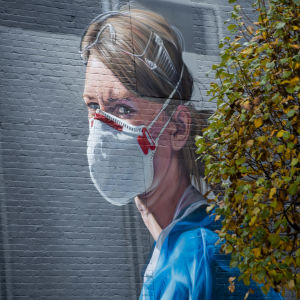 Den överarbetade sjukvårdspersonalen har hyllats på många håll i världen under pandemin. Bild: En väggmålning i brittiska Manchester som föreställer sjukskötaren Melanie Senior. En väggmålning i Manchester som föreställer sjukskötare Melanie Senior.