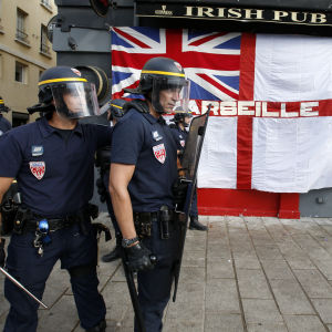 Kravallpoliser väntar bråk mellan engelska och ryska fotbollsfans vid irländska puben i Marseille, Frankrike 2016. Kravallpoliser utanför irländsk pub i marseilles i Frankrike 2016 förbereder sig för slagsmål mellan engelska och ryska fotbollsfans.