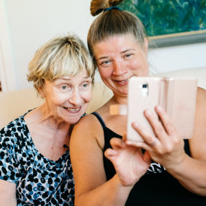 Vanhempi ja nuorempi nainen ottavat yhdessä selfietä.