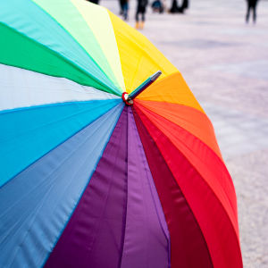 Sateenkaarilipun värinen sateenvarjo.