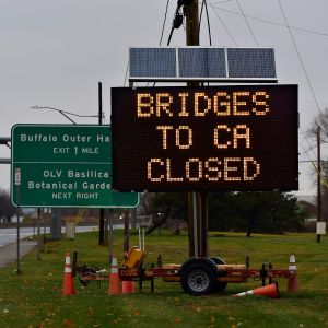 En informationsskylt vid sidan av en motorled meddelar att broarna till Kanada är stängda.