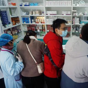 Människor står i kö på ett apotek i Kina.