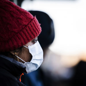 En person med mössa och munskydd i Helsingfors den 25 januari 2022.