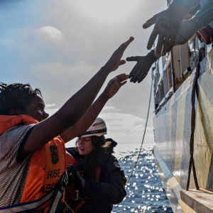 Mission Lifeline -kansalaisjärjestön kautta saadussa kuvassa siirtolainen nousee "Rise Above" -pelastusalukseen sen jälkeen, kun hänet on pelastettu Sisilian rannikolta Etelä-Italiassa marraskuussa 2022.