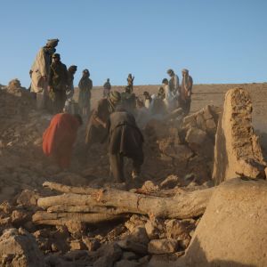 Afghaner utanför förstört hus den 7 oktober 2023.