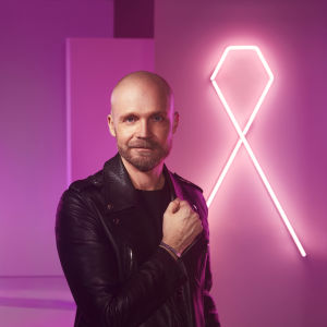 Juha Tapio utmanar finländarna att stöda insamlingen och samtidigt visa att vi är världens mest omtänksamma folk. Juha Tapio som har designat årets Rosa band