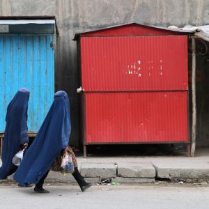 Afghanska burkaklädda kvinnor går längs en gata.
