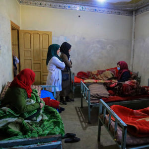 Två kvinnliga anställda står bland sina patienter på en klinik i Kabul som erbjuder vård för drogberoende kvinnor och barn. Verksamheten finansieras med hjälp av internationella donationer. 