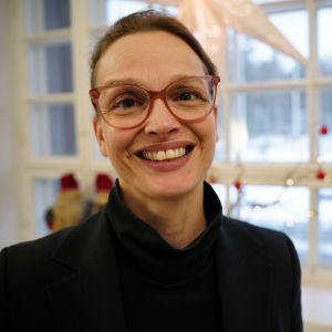 Raseborgs stadsdirektör Petra Theman leende framför ett fönster. 