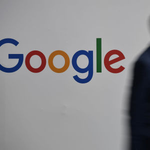 Googlen logon edestä kävelee mies.