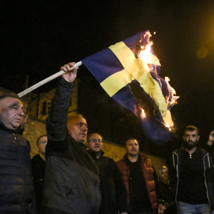 Demonstranter bränner en svensk flagga i Istanbul.