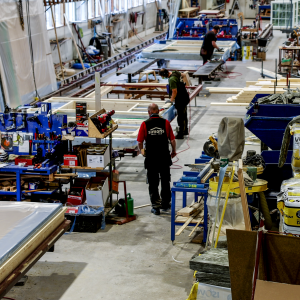 Män arbetar med huselement på fabriksgolv