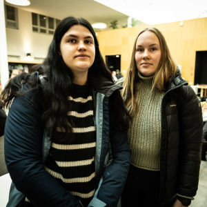 Porträttfoto av två kvinnor i en cafeteria