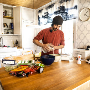 Man i röd tröja häller salt i äggsmet