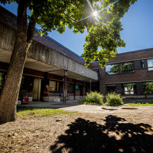 Brungrå betongbyggnad i solsken. 