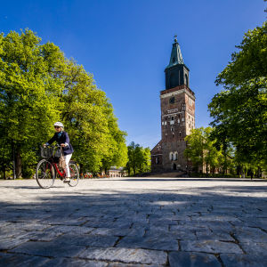 En kvinna cyklar över domkyrkoskvären i Åbo. 