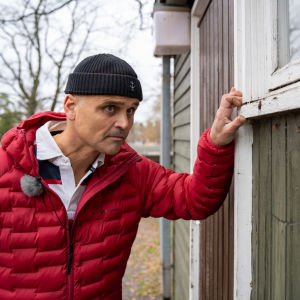 Mikael Sandell granskar en träbyggnad i Ekenäs. 
