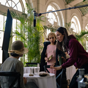 På bilden ses skådespelarna Tessa Thompson och Ruth Negga få instruktioner av regissören Rebecca Hall. De befinner sig i ljus pampig lokal.