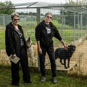 Två kvinnor i mörka kläder står framför hudhagar