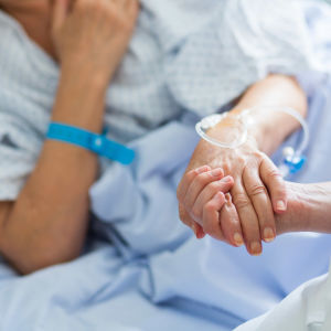 Patient och skötare håller hand.