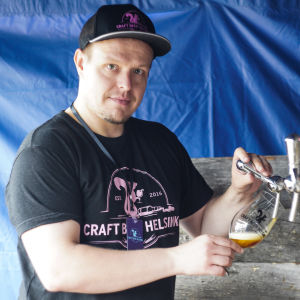 Arrangör Tero Forsberg hoppas på fler besökare än i fjol trots regnet. Tero Frosberg häller upp öl från en kran i ett öltält. Han är arrangör för Craft Beer Helsinki.