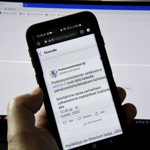 En telefonskärm där Försvarsministeriets Twittermeddelande om att ministeriets webbsida drabbats av en cyberattack.