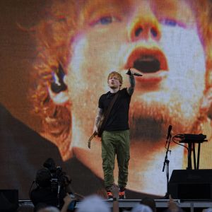 Ed Sheeran på scen med en bild av Ed Sheeran på storskärm bakom honom.