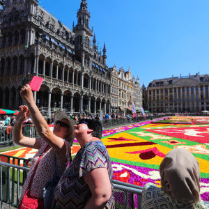 Två damer tar en selfie vid blomstermattan utanför Grand Palace i bryssel. 