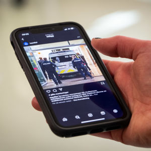 En hand håller i en mobiltelefon med en öppen sociala medier app
