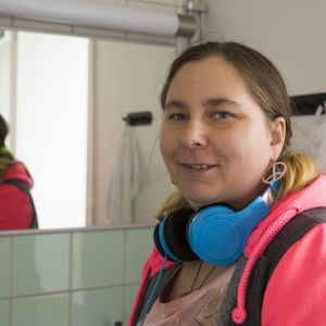 Tintti hymyilee kameralle siivouksen lomassa kylpyhuoneen peilin edessä.
