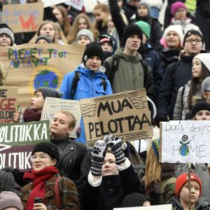 Unga håller upp demonstrationsplakat under klimatstrejk i Helsingfors. 