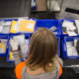Postin työntekijä lajittelee paketteja