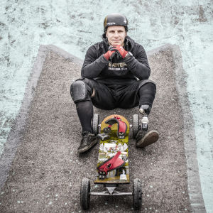 Matti Suur-Hamari kämpade sig tillbaka upp på snowboarden. Matti Suur-Hamari istuu asvaltilla.