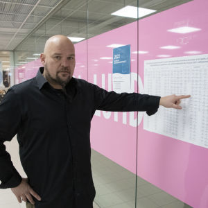 Petri Hosiaisluoma pekar på en kandidatlista vid vallokalen i köpcentret Lundi.