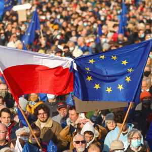 Bild på folkmassa där personer håller upp Polens och EU:s flagga.