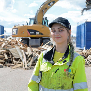 Kvinna står framför traktor.