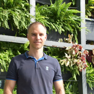 Matti Kontsas hoppas att fler och fler malaysier börjar motionera. Han betonar att det tropiska klimatet inte utgör ett hinder för att det ska gå att röra på sig utomhus. Man i kortärmad skjorta i soligt väder och med en massa gröna växter på hyllor i bakgrunden