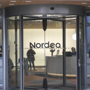 Nordea logo seen on a wall through a revolving door at the bank's headquarters in Helsinki