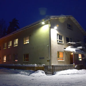 En beige skolbyggnad omringad av snö. På väggen står det Svartå skola.