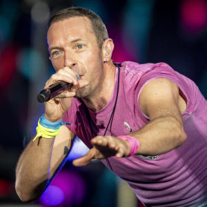 Chris Martin laulaa mikkiin lavalla. 