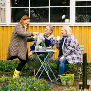 Kädet multaan -ohjelman juontajat Taina Suonio, Enni Koistinen ja Inkeri Alatalo kahvittelevat ulkona.
