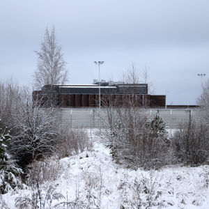 Vankilarakennus lumisessa maisemassa.