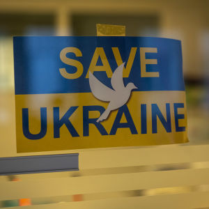 Pelastakaa Ukraina lappu on ripustettu ukrainalaisten apukeskuksen ikkunaan Helsingissä.