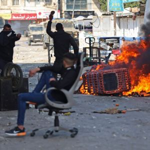 Palestiinalaisia mielenosoittajia kadulla olevan tulipalon läheisyydessä.