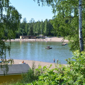 En större simgrop där två barn står vid stranden.