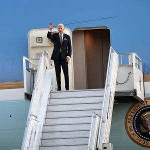 Joe Biden vilkuttaa lentokoneen oviaukon edustalla.