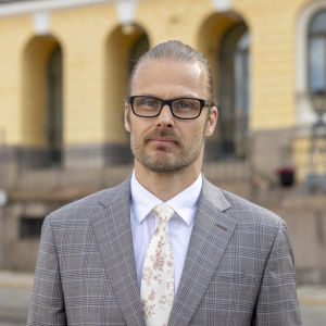Valtiovarainministeriön budjettipäällikkö Mika Niemelä poseeraa valtioneuvoston edustalla (puolilähikuva).