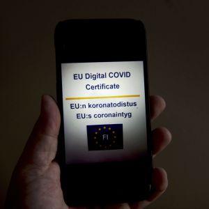 Mobiltelefon med EU:s coronaintyg på skärmen. Intyget kan laddas ner i mobilen från webbplatsen kanta.fi.