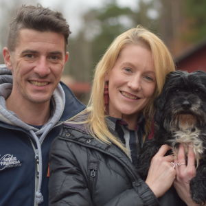 En leende man och kvinna och en hund.